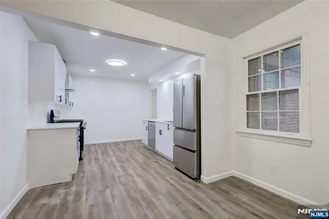 a view of kitchen with stainless steel appliances cabinets and wooden floor