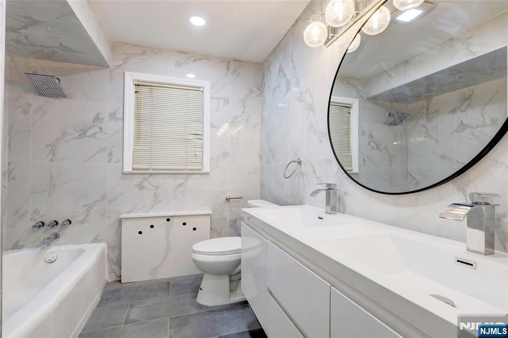 4-21 Saddle River Road, Unit 1 Fair Lawn, NJ 07410 - Photo 8 of 19 a bathroom with a sink and a mirror