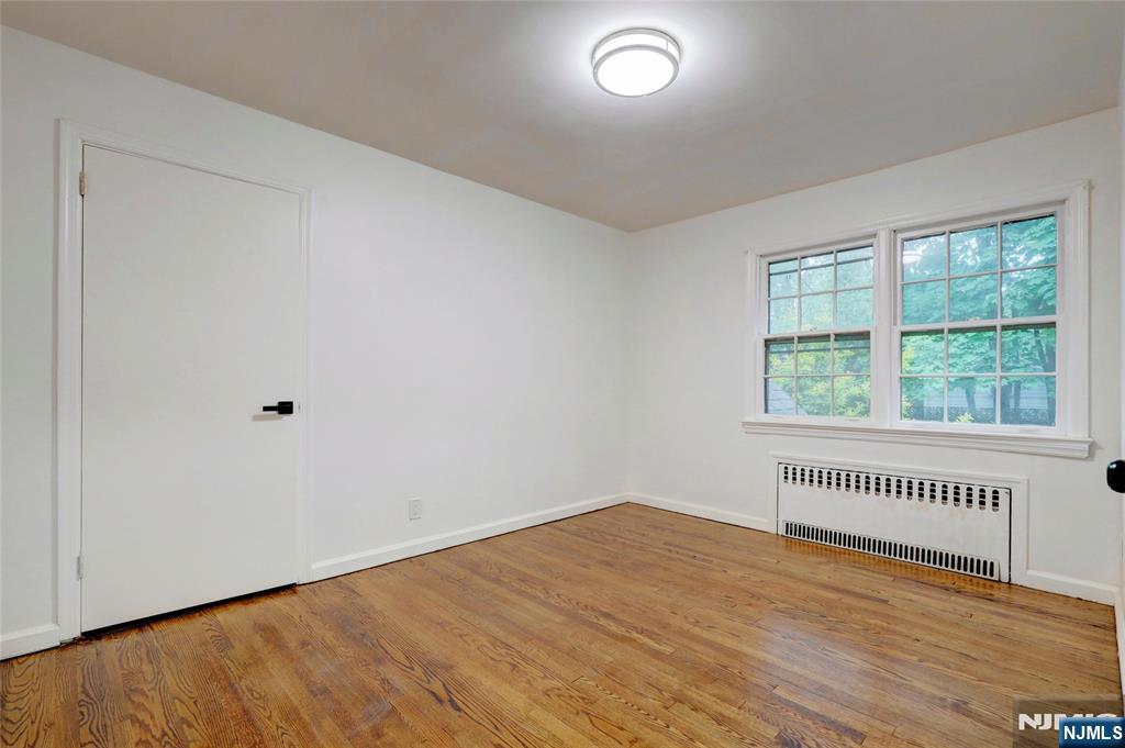 4-21 Saddle River Road, Unit 1 Fair Lawn, NJ 07410 - Photo 9 of 19 an empty room with wooden floor and windows