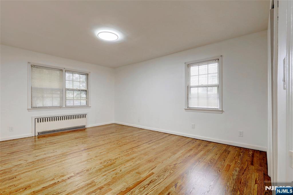 4-21 Saddle River Road, Unit 1 Fair Lawn, NJ 07410 - Photo 10 of 19 an empty room with wooden floor and windows