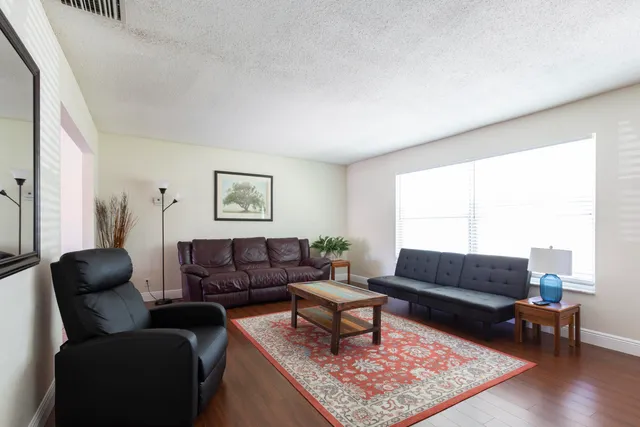 a living room with furniture a rug and a window