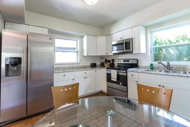 a kitchen with stainless steel appliances granite countertop a stove a sink and a refrigerator