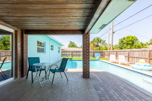 a view of a patio with table and chairs and wooden floor