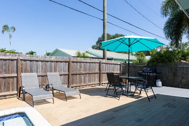 a view of backyard with seating space and wooden fence