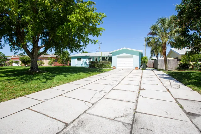 a front view of a house with a yard and trees