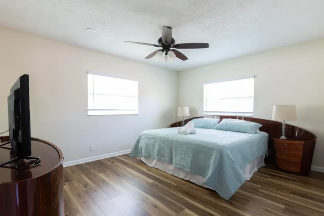 a bedroom with a bed and a flat tv screen on a dresser