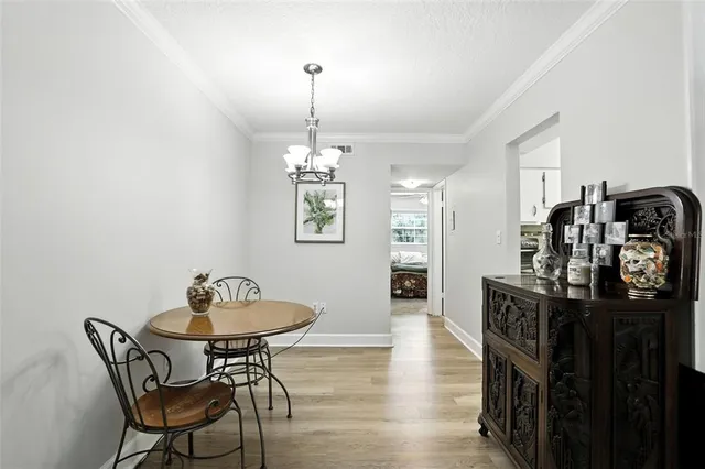 a view of a dining room and livingroom with furniture wooden floor a chandelier