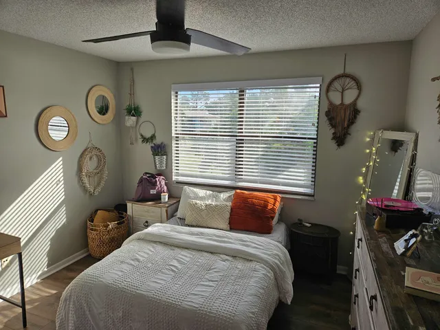 a bedroom with a large bed and a clock on the dresser