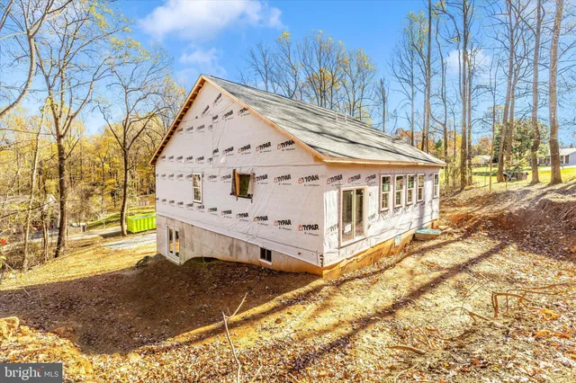 a view of house with yard and sitting area