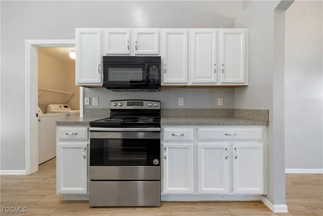 a kitchen with white cabinets and stainless steel appliances