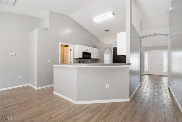 a view of a kitchen with wooden floor and electronic appliances