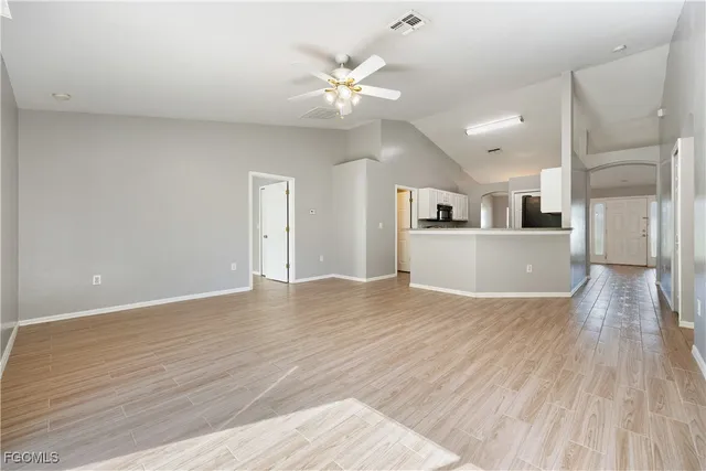 a view of a kitchen with wooden floor and a ceiling fan