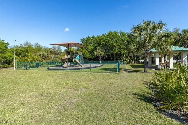 a view of a garden with a table and chairs under an umbrella