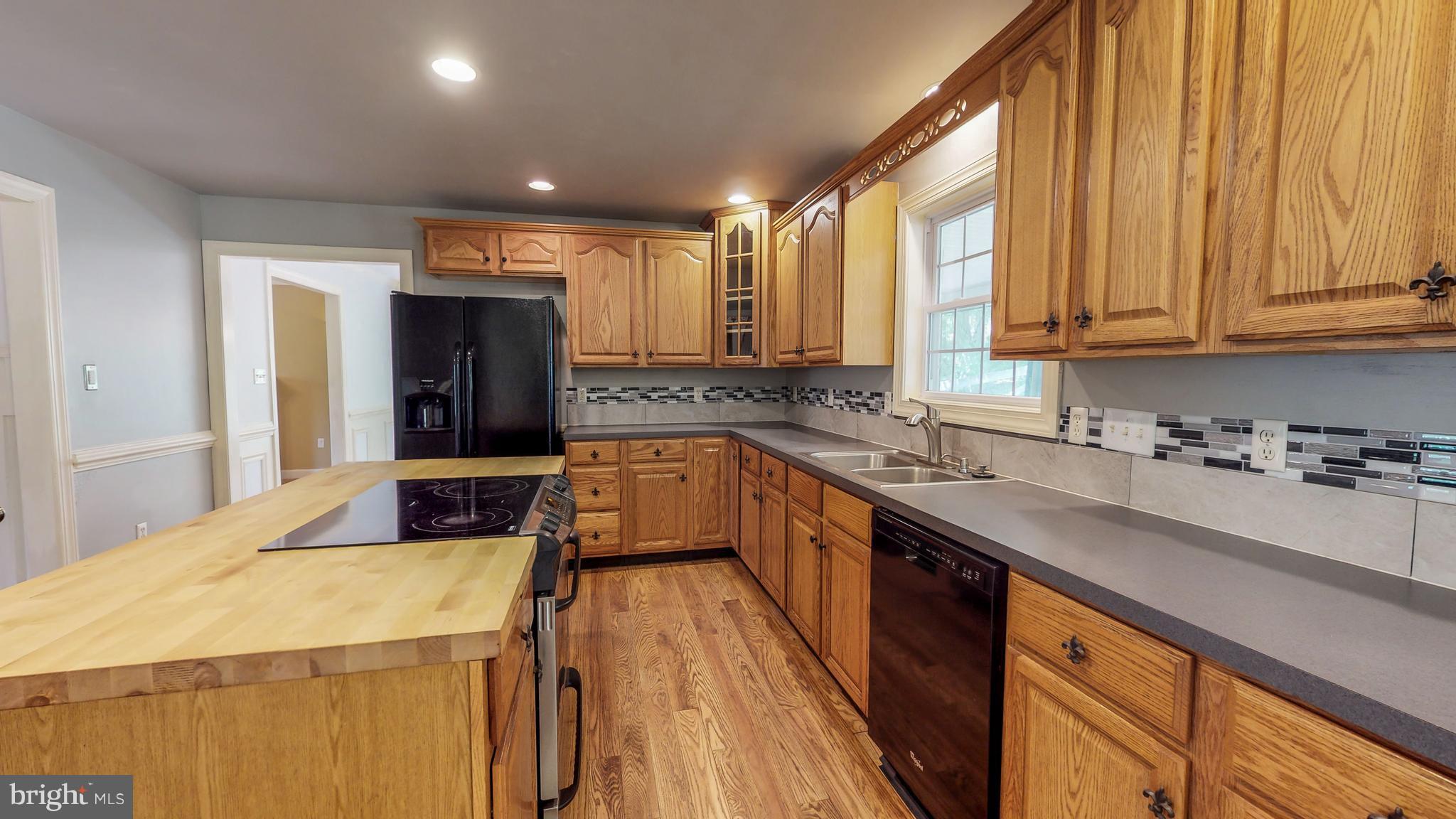 141 Holiday Road Cross Junction, VA 22625 - Photo 11 of 30 a kitchen with kitchen island granite countertop a sink appliances cabinets and a counter top space