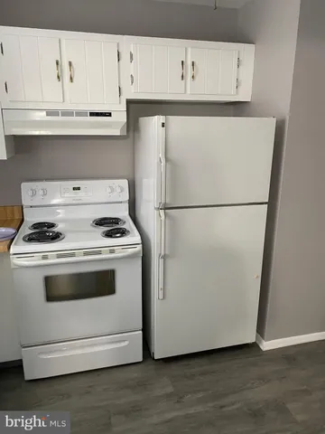 a white refrigerator freezer and a stove sitting inside of a kitchen