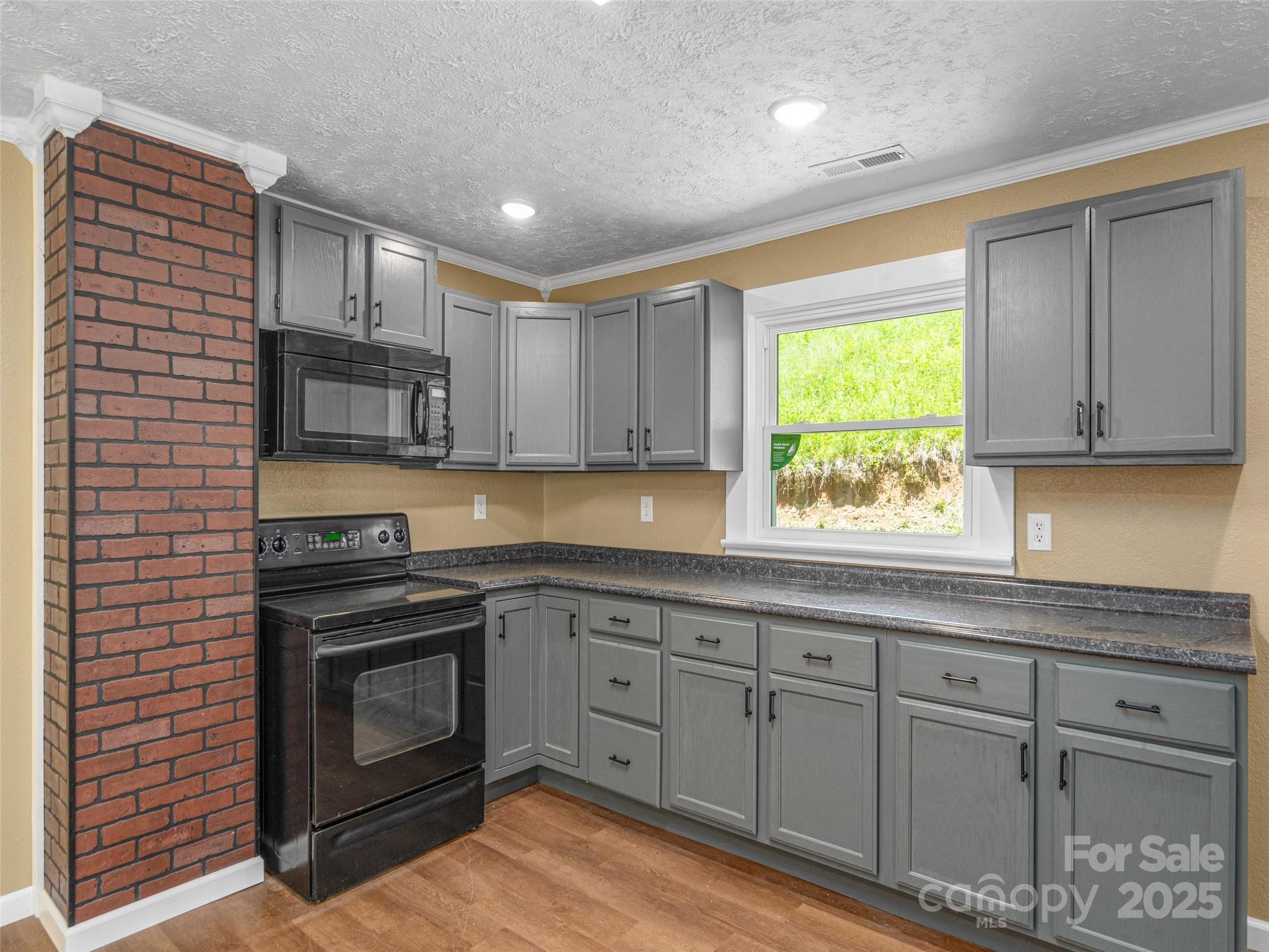 280 Noland Drive Clyde, NC 28721 - Photo 13 of 32 a kitchen with granite countertop a stove top oven sink and cabinets
