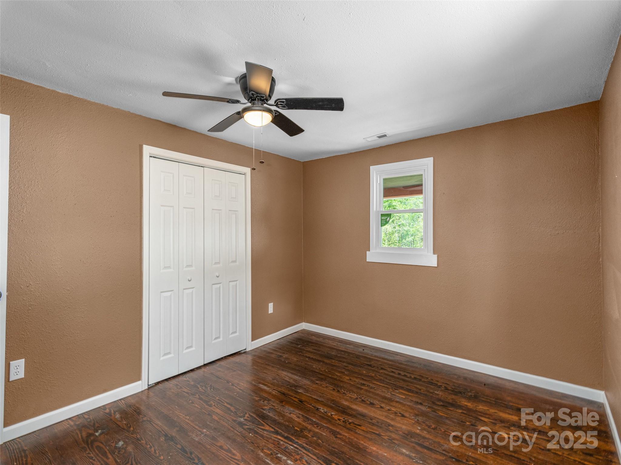 280 Noland Drive Clyde, NC 28721 - Photo 16 of 32 a view of an empty room with wooden floor and a window