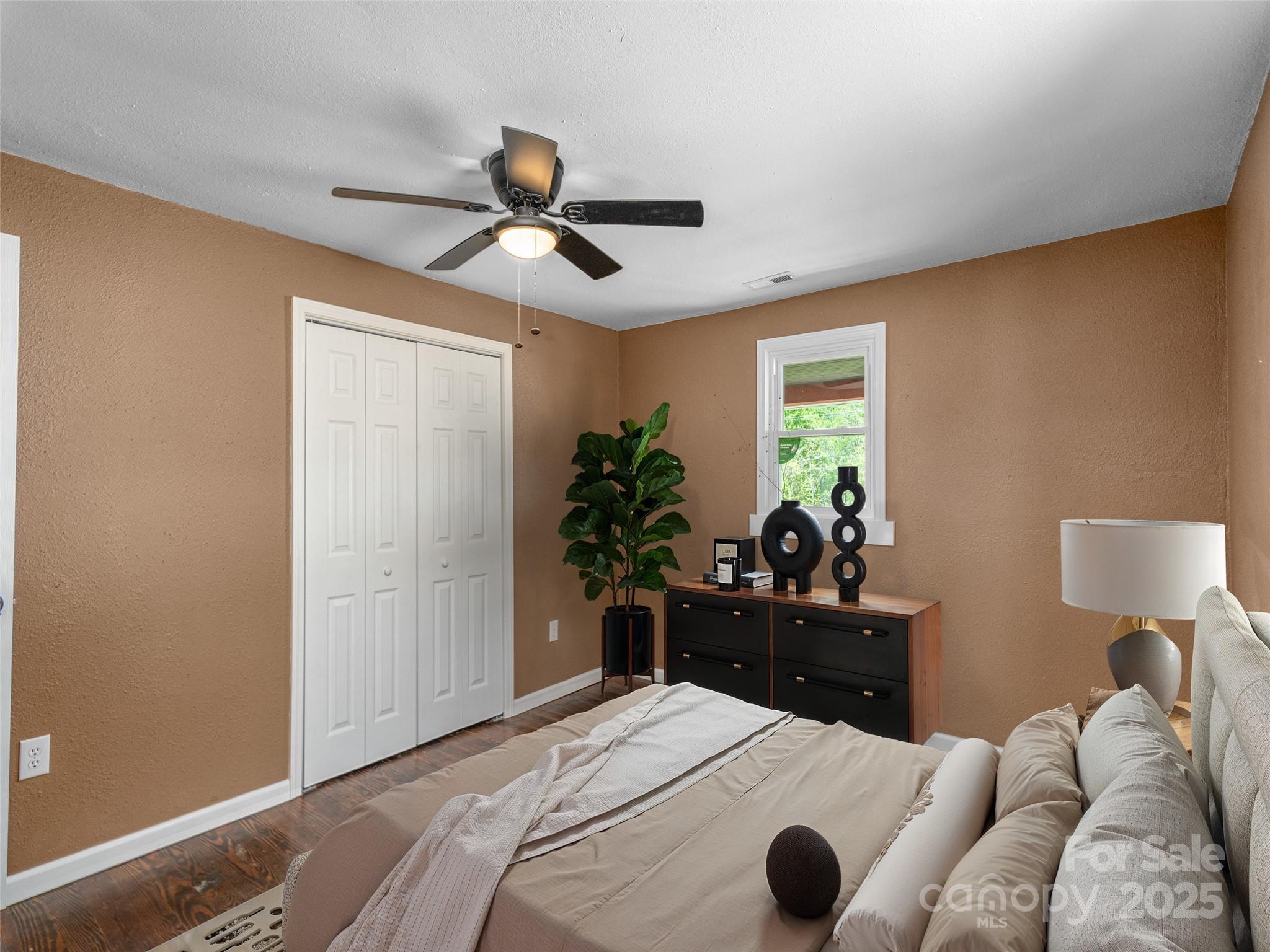 280 Noland Drive Clyde, NC 28721 - Photo 17 of 32 a bedroom with a bed and ceiling fan