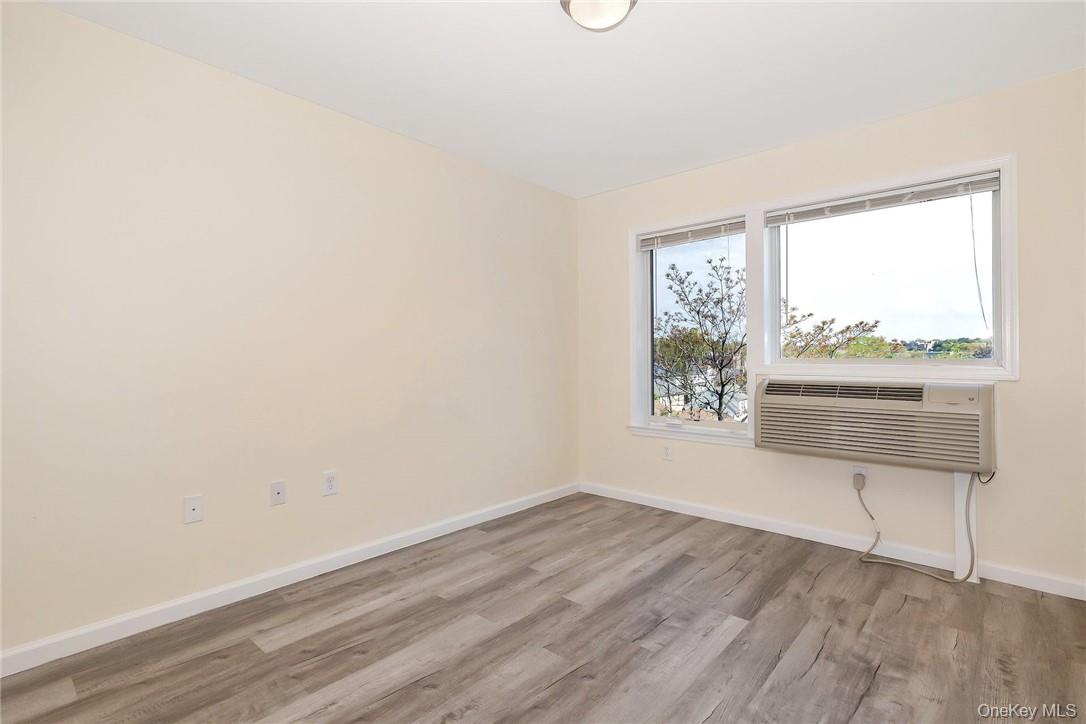 68 Lake Street, Unit 108 White Plains, NY 10601 - Photo 6 of 36 a view of an empty room with a window and wooden floor