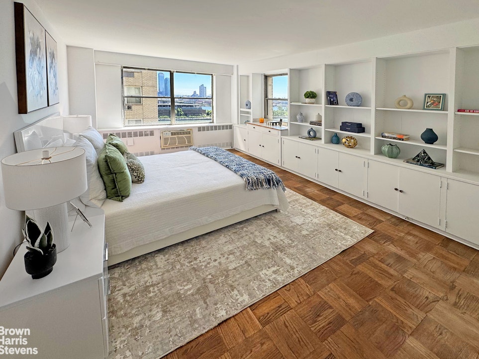 35 Sutton Place, Unit 14F Manhattan, NY 10022 - Photo 3 of 15 a bedroom with a bed a large window and wall painting