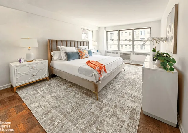 a bedroom with a bed a large window and wall painting