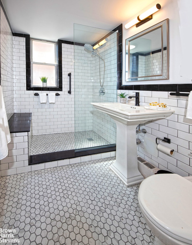 35 Sutton Place, Unit 14F Manhattan, NY 10022 - Photo 8 of 15 a bathroom with a sink a toilet a mirror and shower