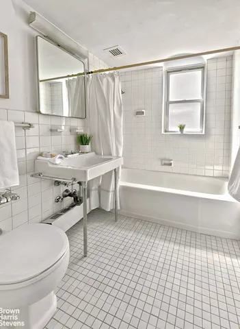 a bathroom with a sink a toilet a mirror and shower