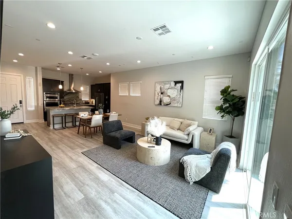 a living room with furniture and a view of kitchen