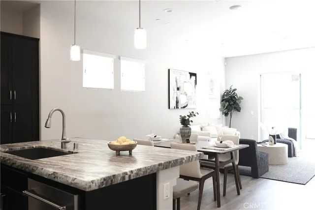 a kitchen with a granite countertop sink and white cabinets