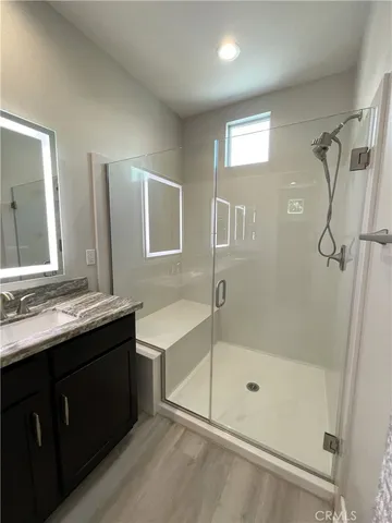 a bathroom with a bathtub shower sink vanity and mirror