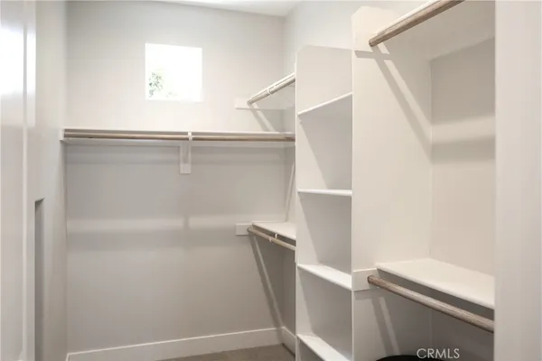a view of walk in closet with empty racks