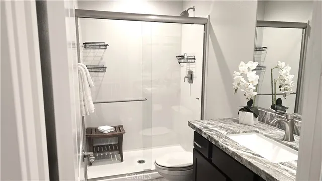 a bathroom with a granite countertop sink toilet a shower and a mirror