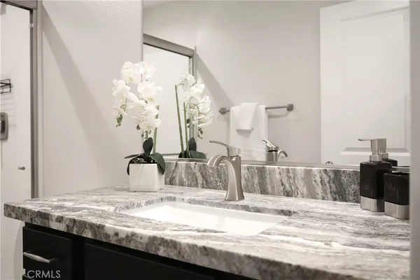 a bathroom with a granite countertop sink and a mirror