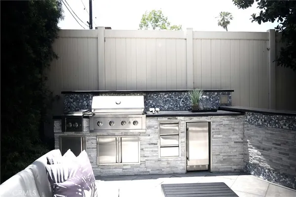 a kitchen with granite countertop a stove a sink and white cabinets