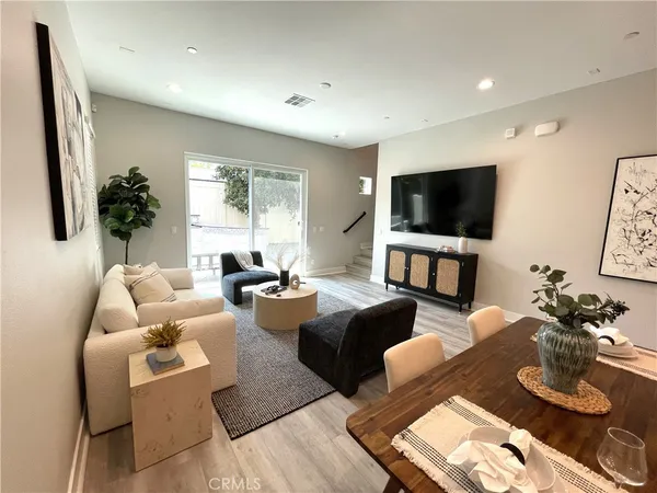 a living room with furniture a flat screen tv and a large window