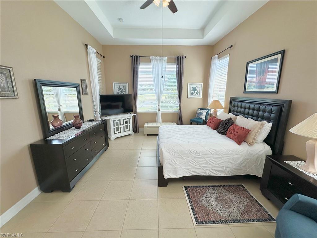 2956 Willow Ridge Court Fort Myers, FL 33905 - Photo 5 of 24 a bedroom with a bed a mirror on dresser and a chandelier