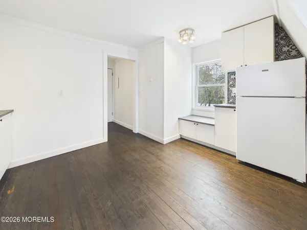 a view of a kitchen with wooden floor and electronic appliances