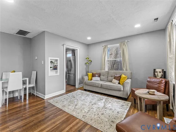 a living room with furniture and wooden floor