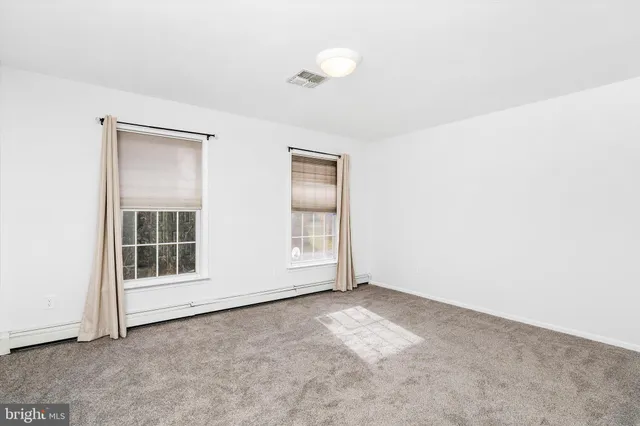 an empty room with windows and closet