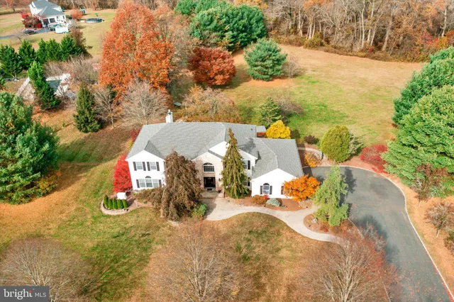 an aerial view of a house with a yard and lake view