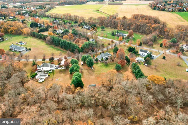 an aerial view of residential houses with outdoor space and lake view