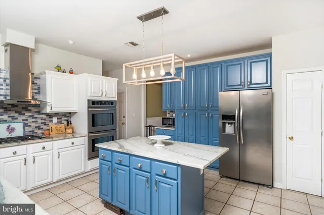 a kitchen with a refrigerator sink and cabinets