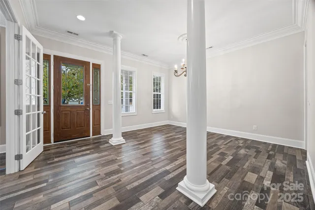 a view of a room with wooden floor and a ceiling fan