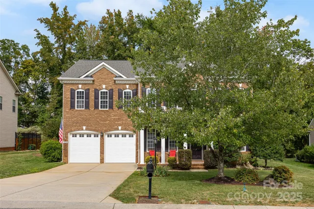 a front view of a house with a yard and trees