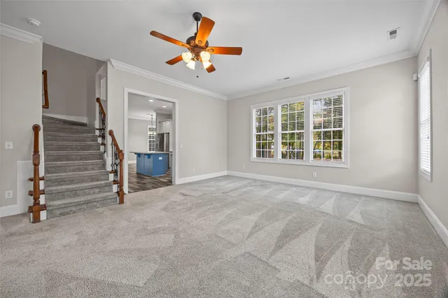 an empty room with a ceiling fan and a window