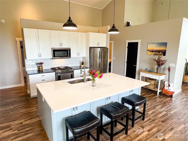 a large kitchen with sink a microwave and refrigerator
