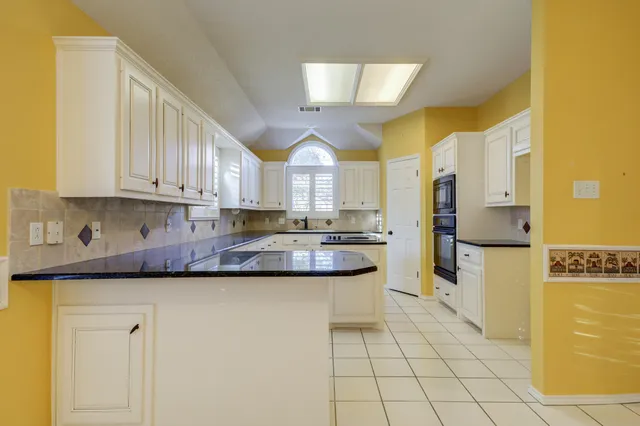 a kitchen that has a sink cabinets counter space and appliances