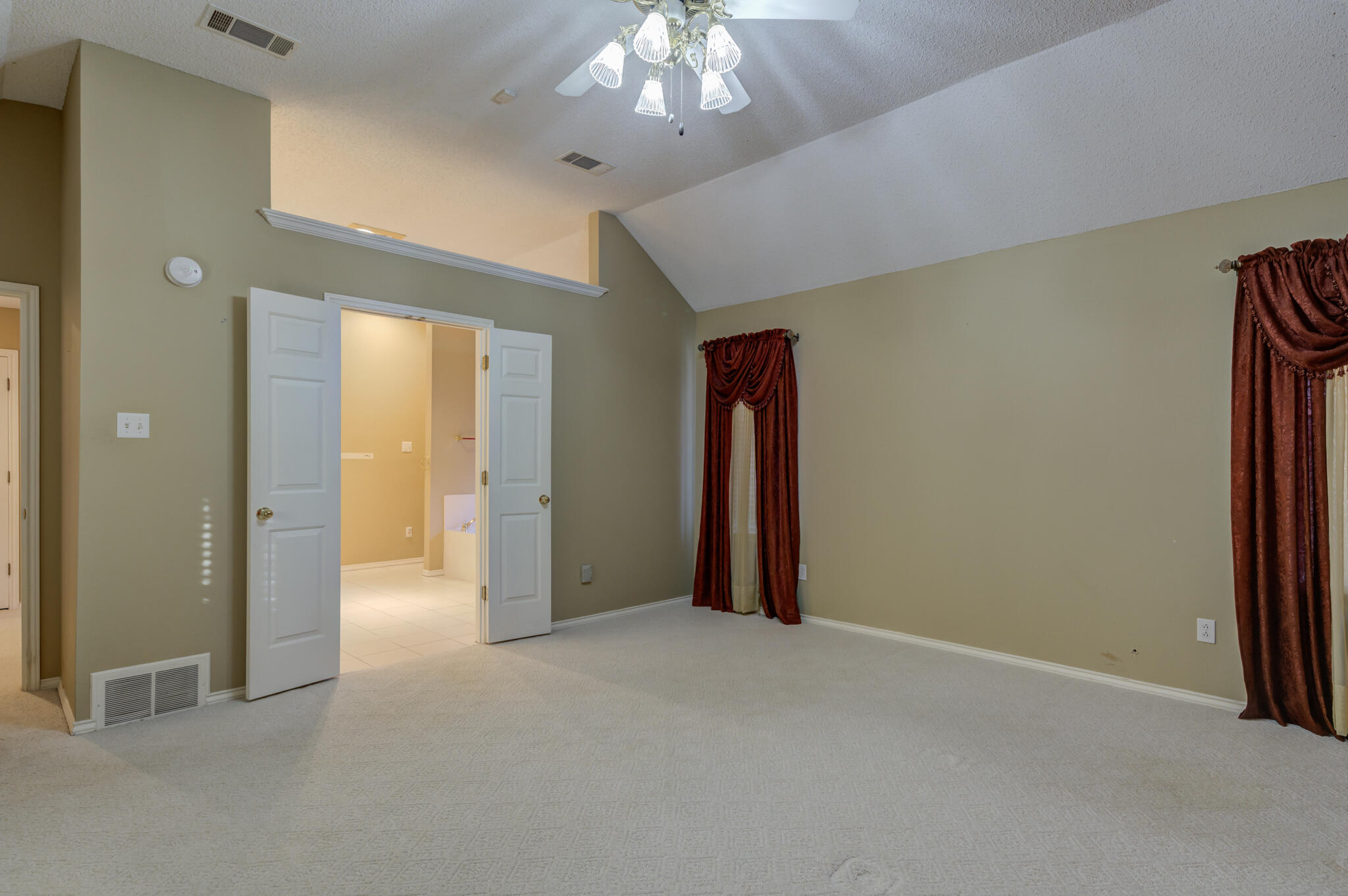 5917 85th Street Lubbock, TX 79424 - Photo 31 of 51 a view of an empty room with a chandelier fan and a bathroom