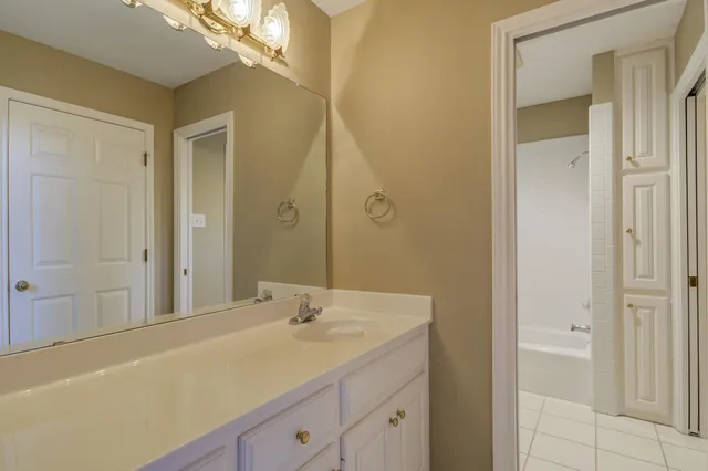 a bathroom with a toilet sink vanity and mirror