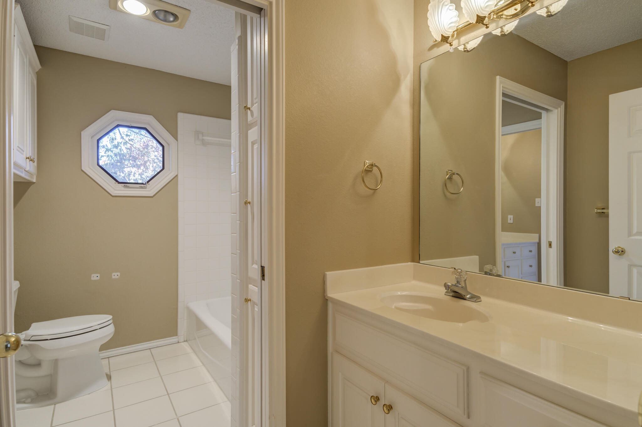 5917 85th Street Lubbock, TX 79424 - Photo 42 of 51 a bathroom with a toilet sink vanity and mirror
